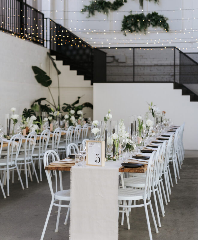A stunning tablescape at The Wool Mill, beautifully styled by The Goodsmiths and adorned with exquisite white florals by Anatomy of Flowers, complemented by a carefully curated color palette, creating a sophisticated and elegant atmosphere for the celebration.