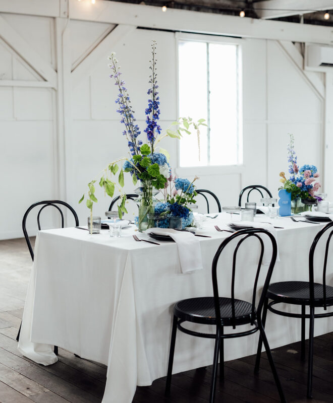 Elegant seated wedding reception at Gather and Tailor, styled by The Goodsmiths with beautiful blue and purple floral arrangements by Anatomy of Flowers. This luxury Melbourne wedding venue offers a sophisticated and timeless setting for a custom-designed celebration.