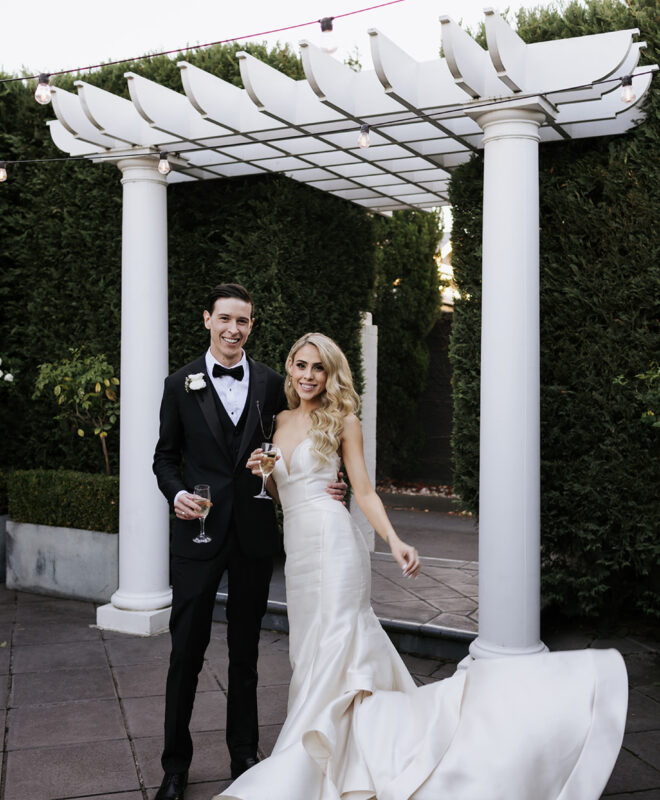 Happy couple sharing a romantic moment in the beautiful Ivory Rose Garden at The Ivory Elsternwick, surrounded by lush greenery and creating a perfect wedding memory.
