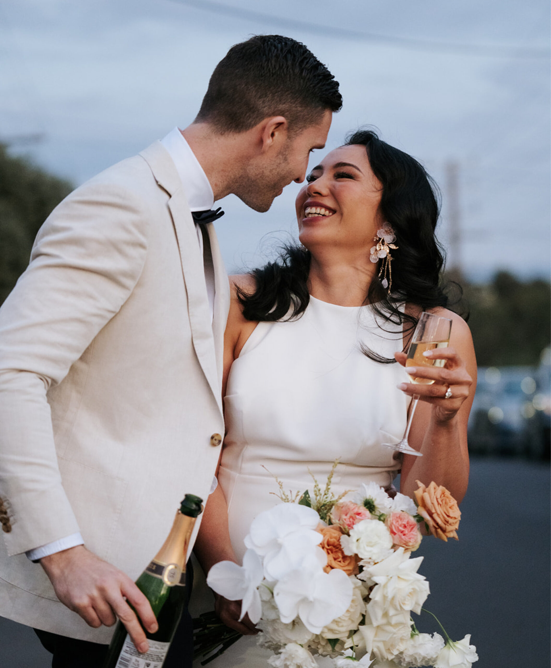 Love and laughter fill the air as a beaming couple celebrates, holding exquisite florals by Anatomy of Flowers, expertly captured by Art of Grace.