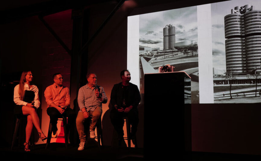 Speaker panel on a stage giving a presentation at Two Ton Max.
